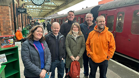 Group of alumni at great railway station smiling at the camera